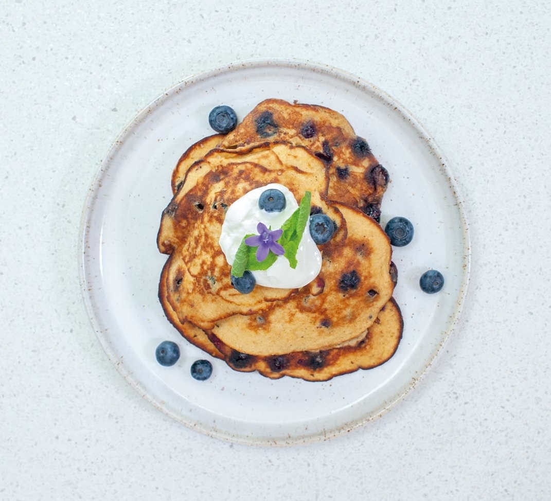 Blueberry oatmeal pancakes with a spoonful of natural yogurt on top.
